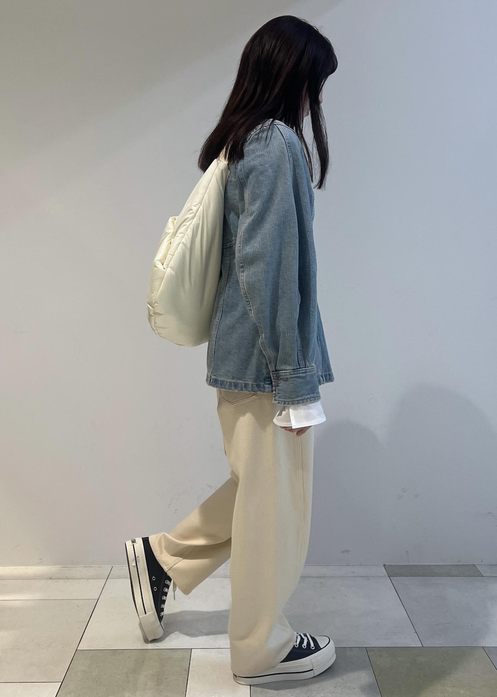 ホワイト系のショルダーバッグ、ホワイト系のその他パンツ、ホワイト系のTシャツ/カットソーを着用したレディースの冬コーディネートの2枚目の写真