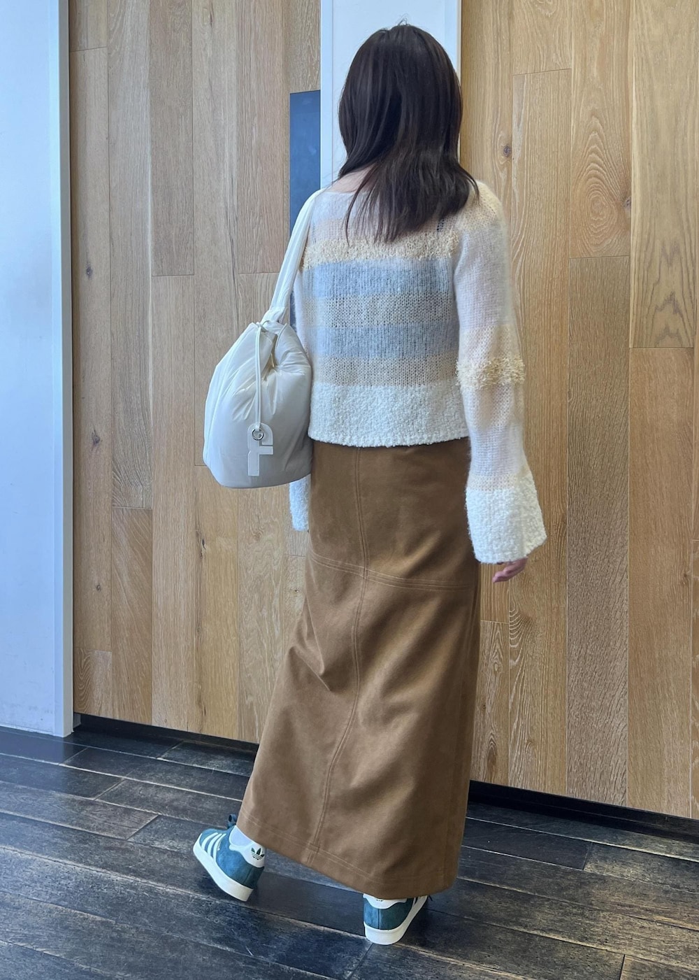 ホワイト系のニット/セーター、ホワイト系のショルダーバッグ、イエロー系のスカートを着用したレディースの秋コーディネートの2枚目の写真