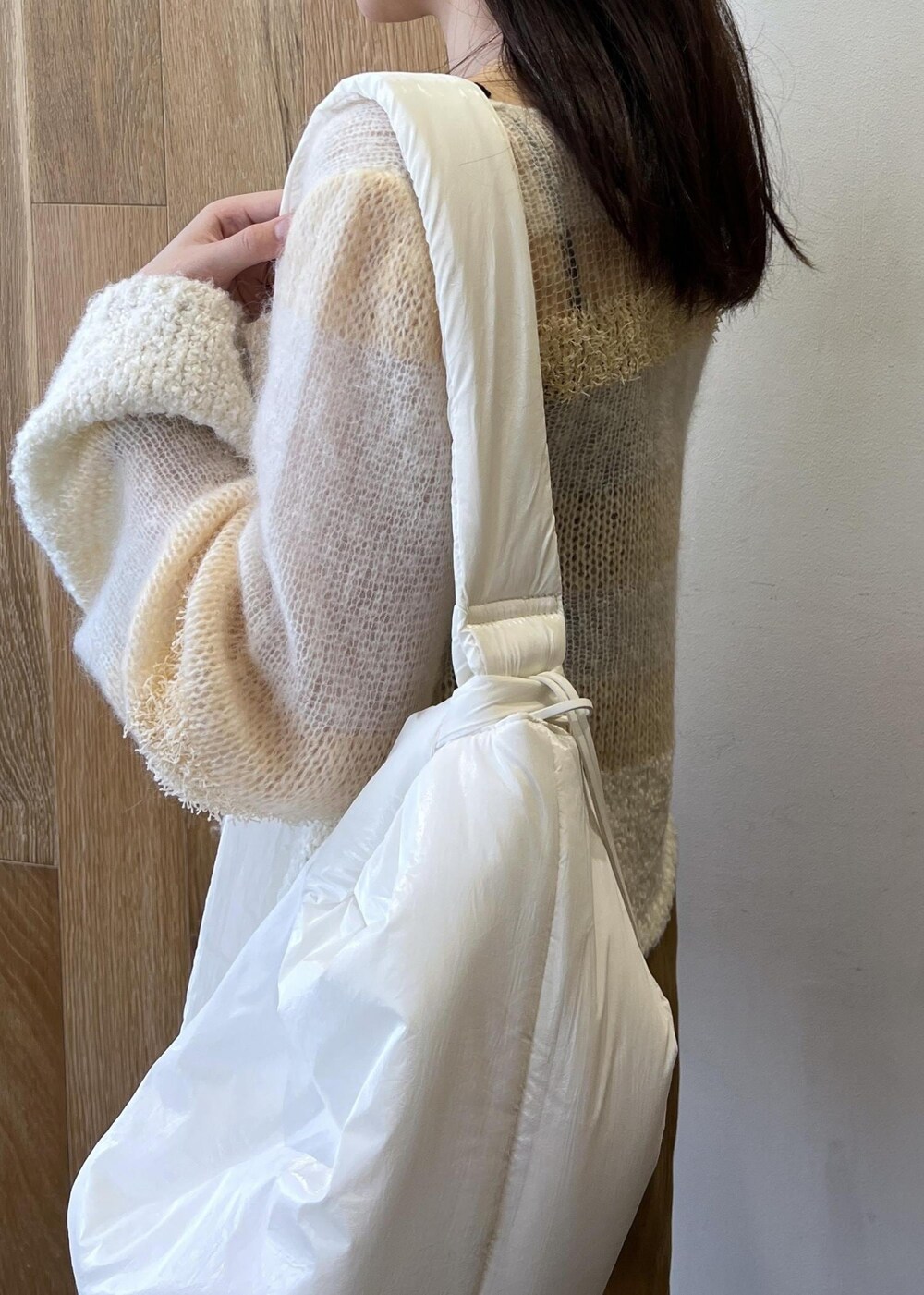 ホワイト系のニット/セーター、ホワイト系のショルダーバッグ、イエロー系のスカートを着用したレディースの秋コーディネートの4枚目の写真