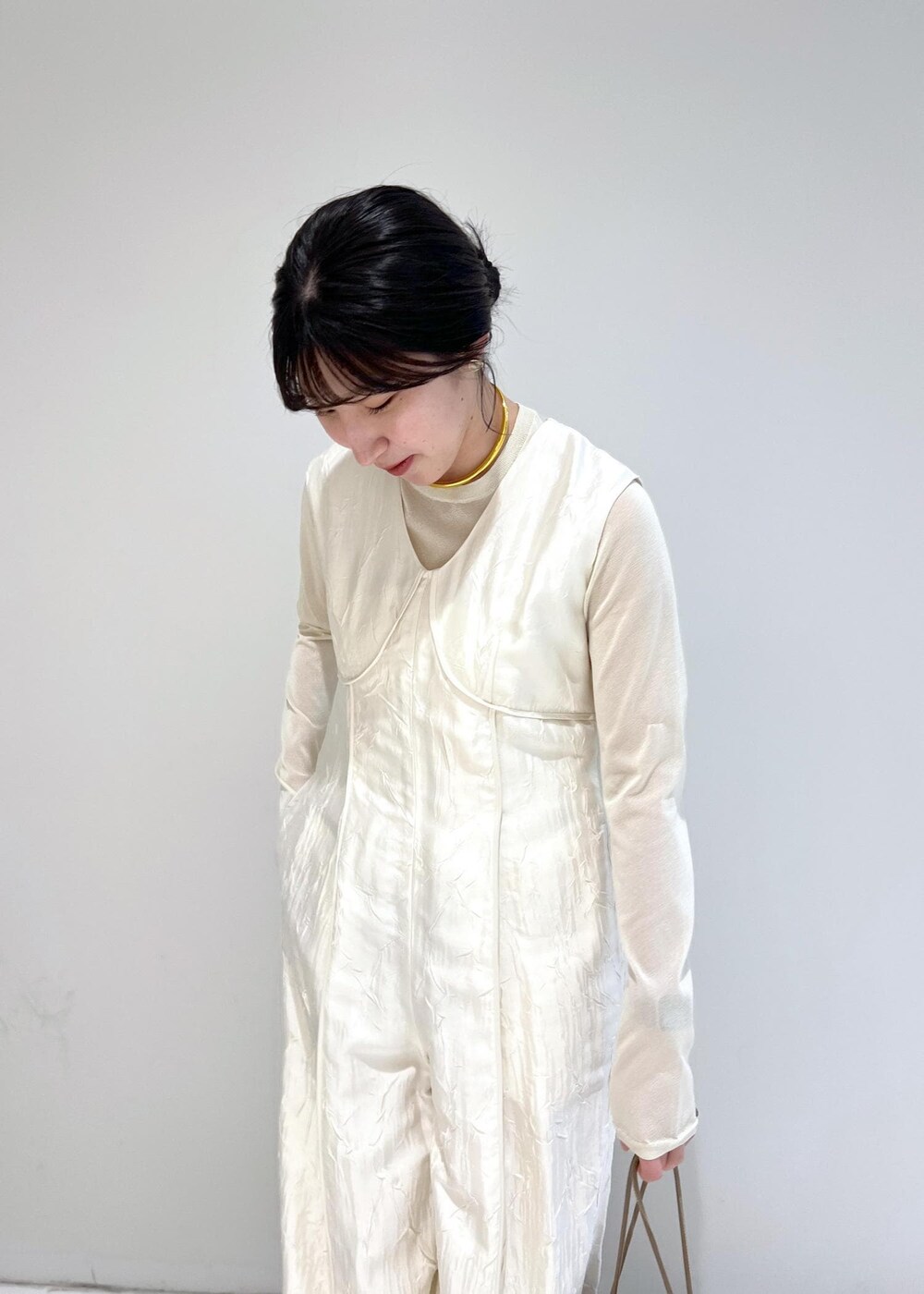 ホワイト系のTシャツ/カットソー、ブラウン系のショルダーバッグ、ホワイト系のつなぎ/オールインワンを着用したレディースの冬コーディネートの4枚目の写真