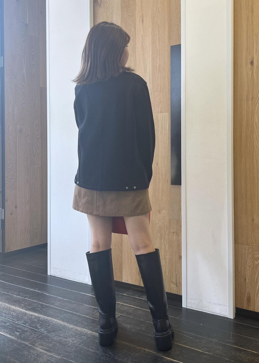 ブラック系のブーツ、ベージュ系のスカート、ブラック系のカーディガン/ボレロを着用したレディースの秋コーディネートの3枚目の写真