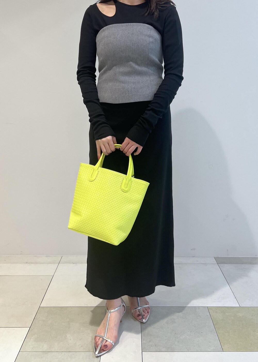 シルバー系のサンダル、ブラック系のワンピース、グリーン系のトートバッグを着用したレディースの春コーディネートの3枚目の写真