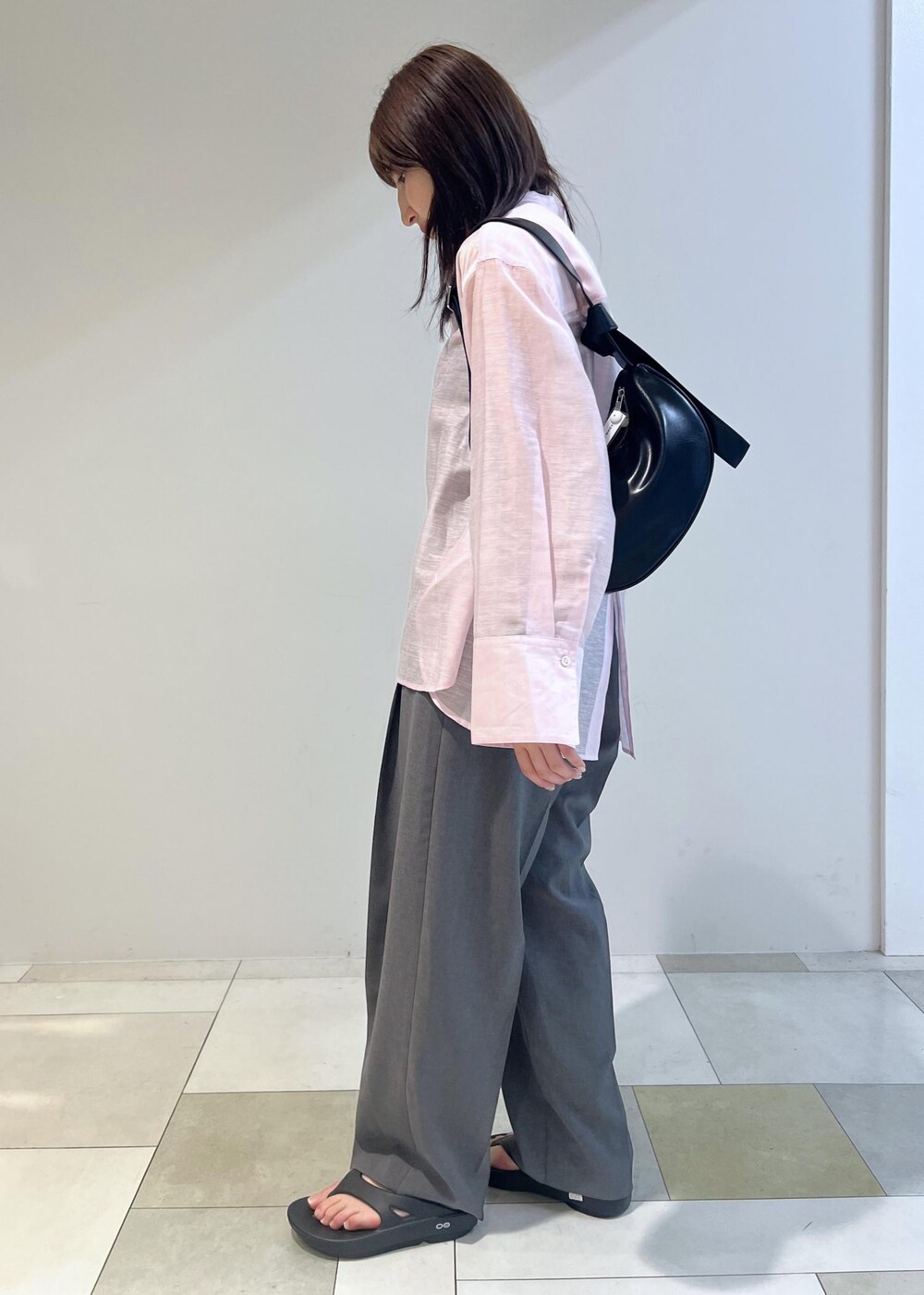 ブラック系のショルダーバッグ、ピンク系のシャツ/ブラウス、グレー系のスラックスを着用したレディースの春コーディネートの4枚目の写真