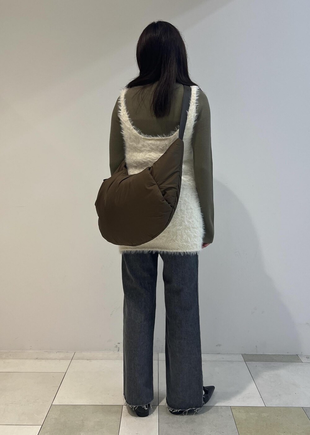 グレー系のデニムパンツ、ブラック系のパンプス、グリーン系のニット/セーターを着用したレディースの秋コーディネートの3枚目の写真