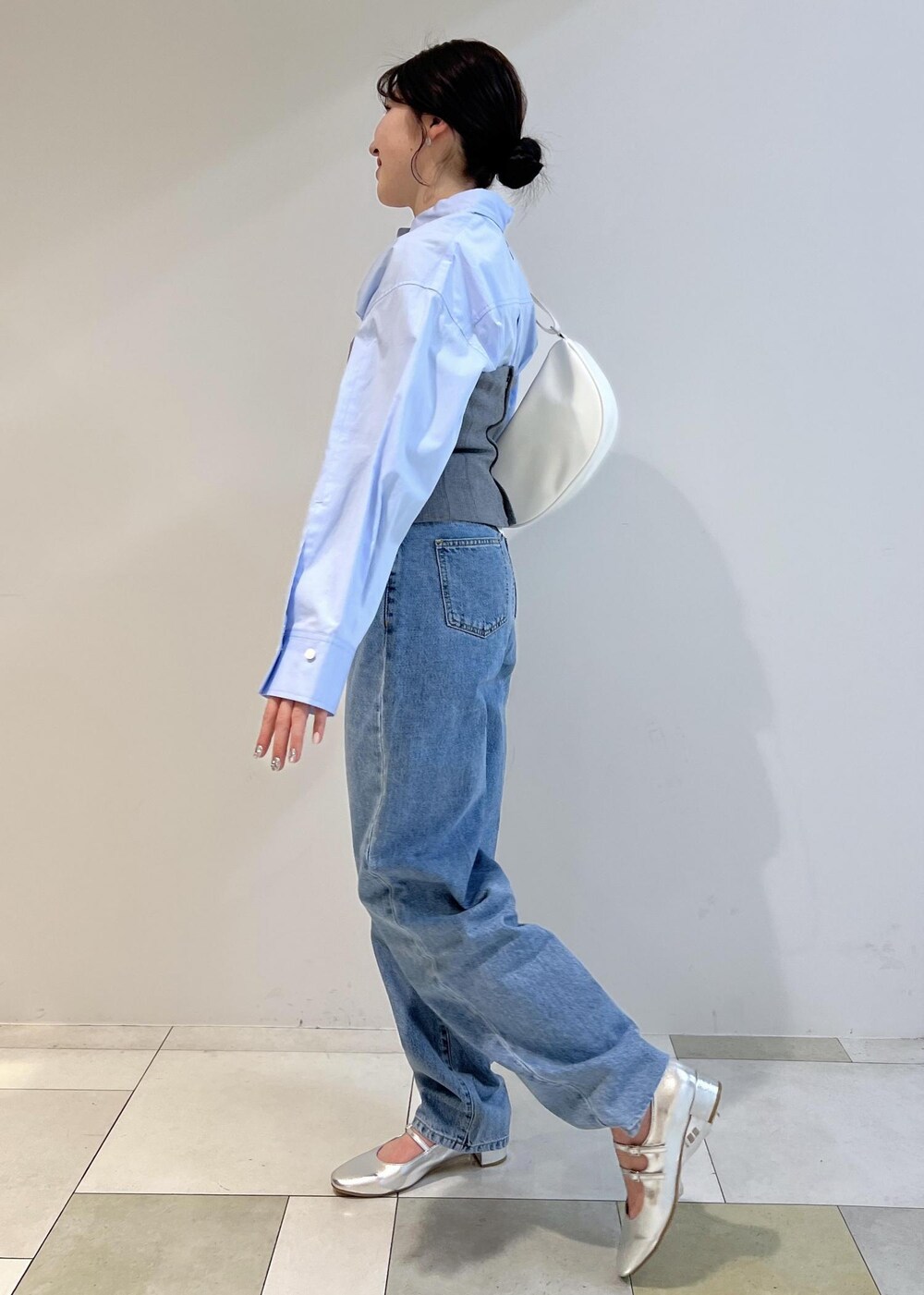 シルバー系のパンプス、ブルー系のシャツ/ブラウス、ホワイト系のショルダーバッグを着用したレディースの春コーディネートの2枚目の写真