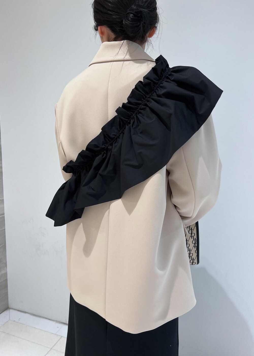 ブラック系のパンプス、ブラック系のワンピース、ベージュ系のテーラードジャケットを着用したレディースの冬コーディネートの6枚目の写真