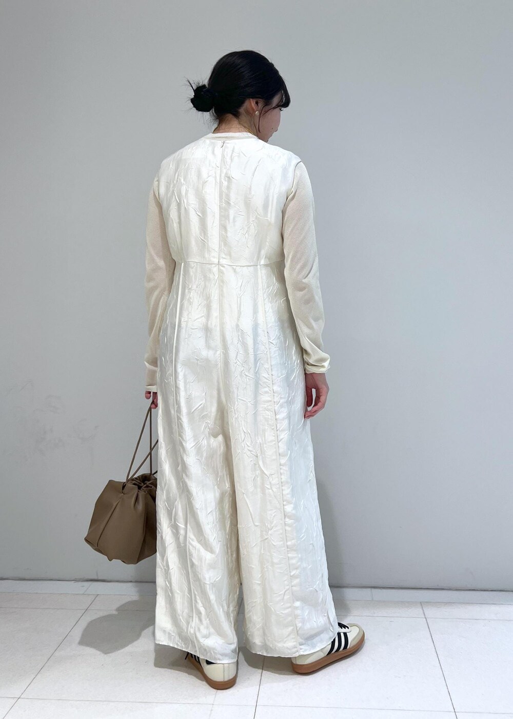 ホワイト系のTシャツ/カットソー、ブラウン系のショルダーバッグ、ホワイト系のつなぎ/オールインワンを着用したレディースの冬コーディネートの3枚目の写真