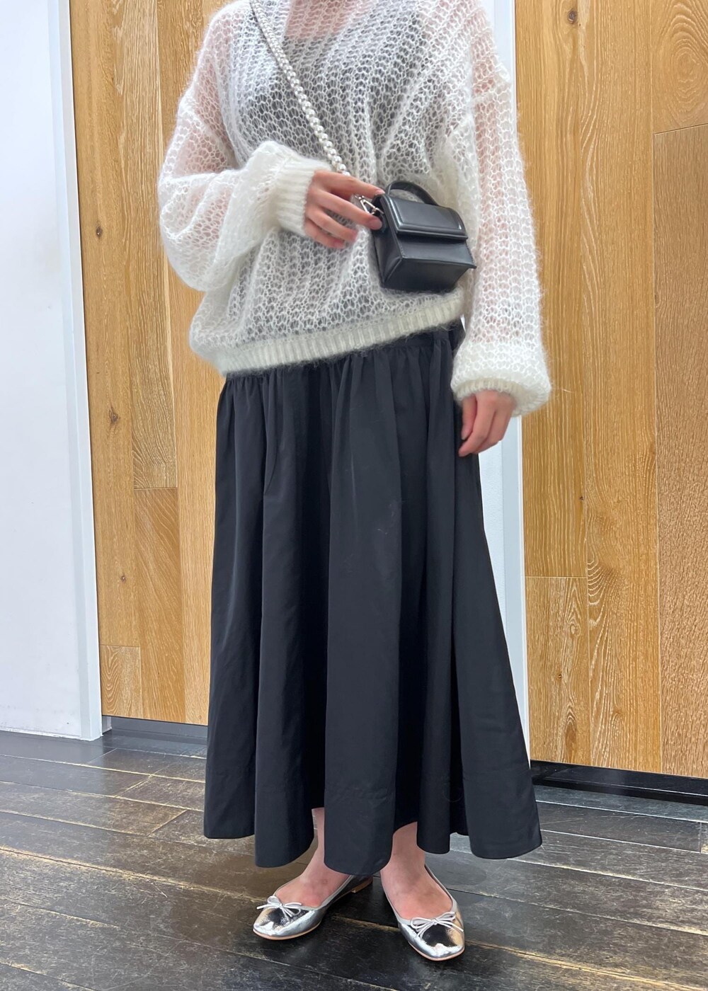 シルバー系のバレエシューズ、ホワイト系のニット/セーター、ブラック系のスカートを着用したレディースの夏コーディネートの4枚目の写真