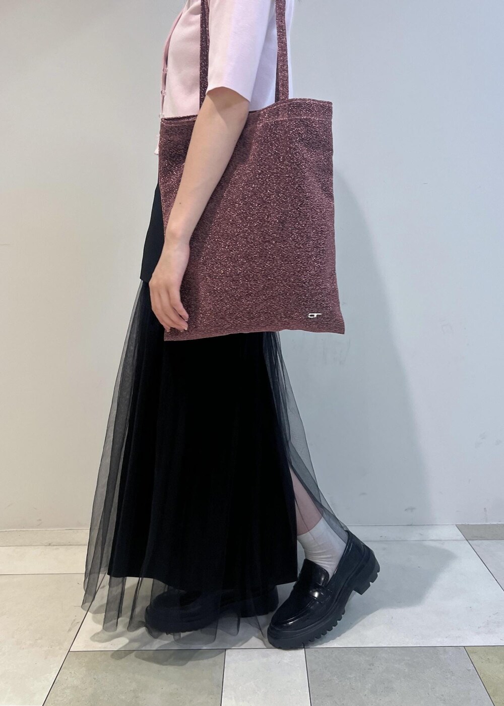 ブラック系のローファー、ブラック系のスカート、ピンク系のトートバッグを着用したレディースの夏コーディネートの6枚目の写真