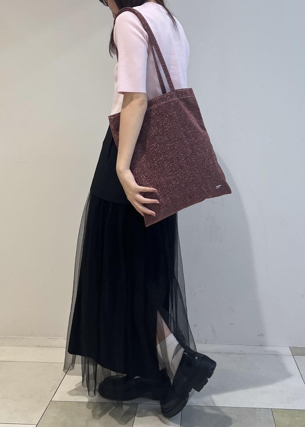 ブラック系のローファー、ブラック系のスカート、ピンク系のトートバッグを着用したレディースの夏コーディネートの2枚目の写真