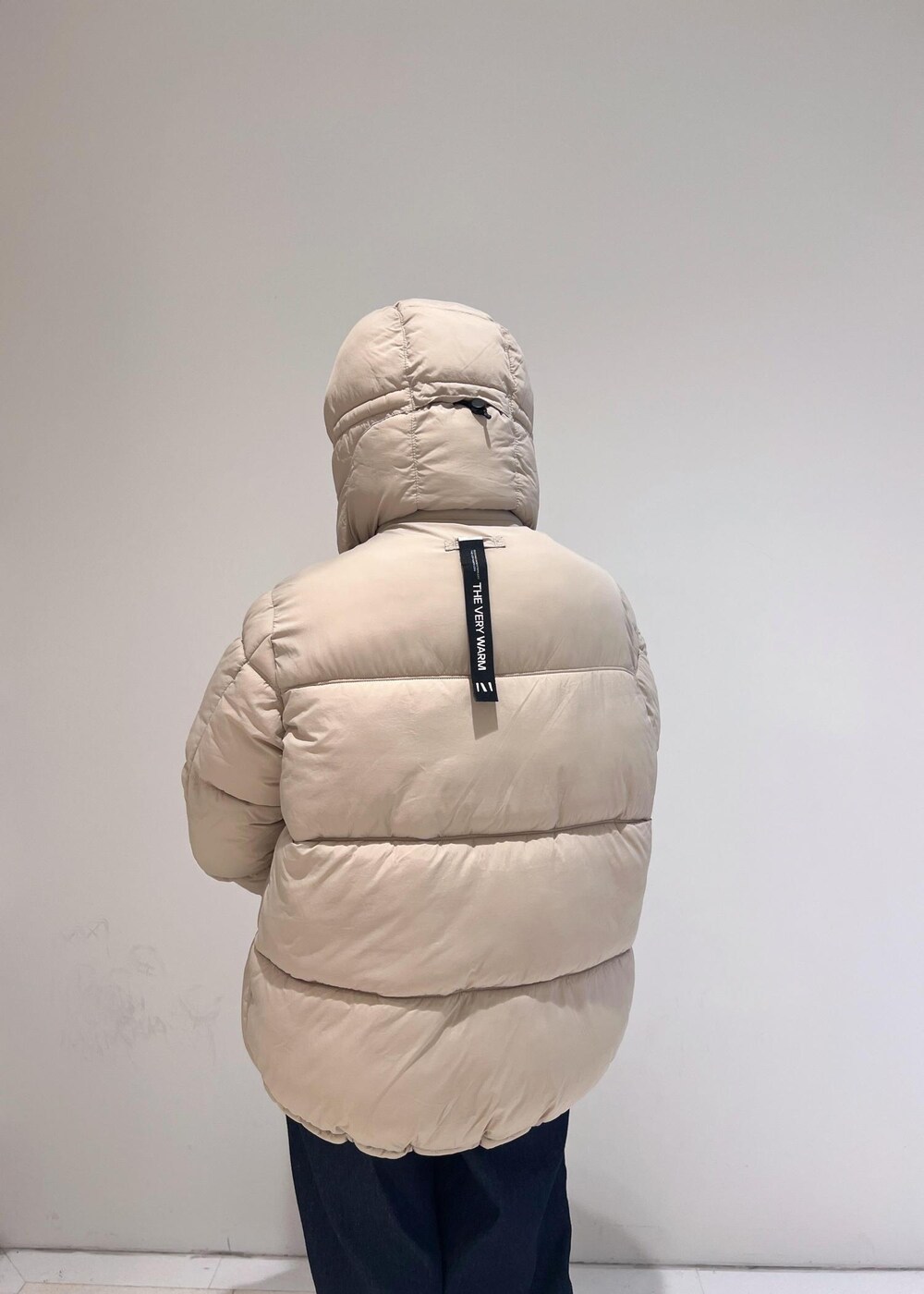 ブルー系のデニムパンツ、ベージュ系のダウンジャケット/コート、ベージュ系のモカシン/デッキシューズを着用したレディースの秋コーディネートの7枚目の写真