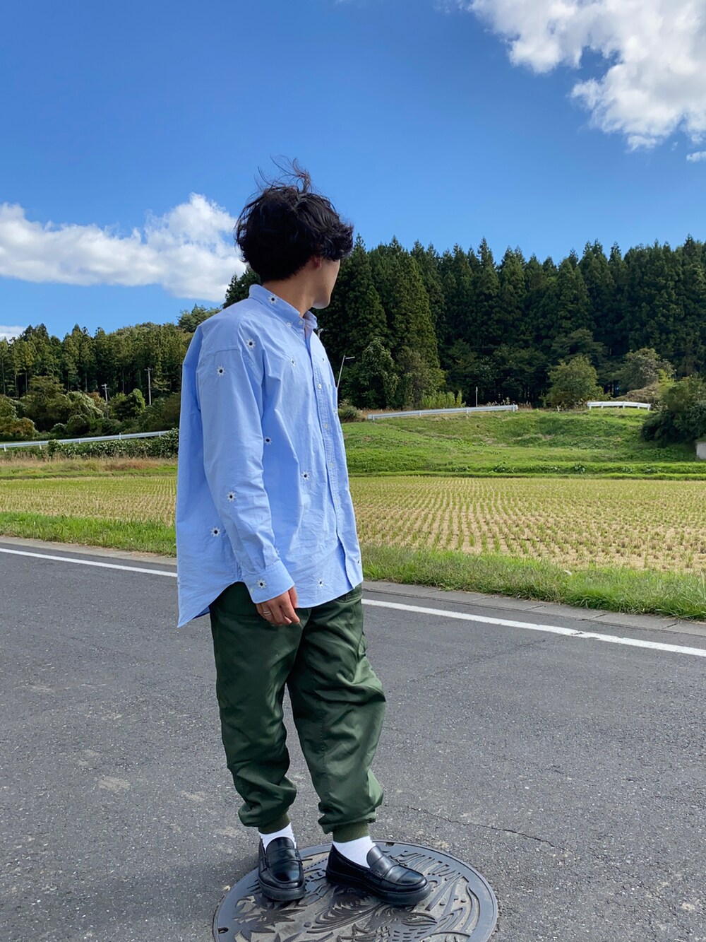 ブルー系のシャツ/ブラウス、グリーン系のその他パンツ、ブラック系のローファーを着用したメンズの秋コーディネートの3枚目の写真