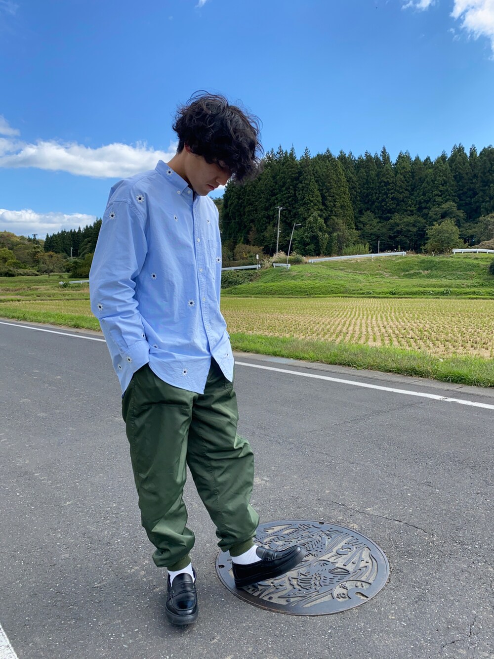 ブルー系のシャツ/ブラウス、グリーン系のその他パンツ、ブラック系のローファーを着用したメンズの秋コーディネートの2枚目の写真