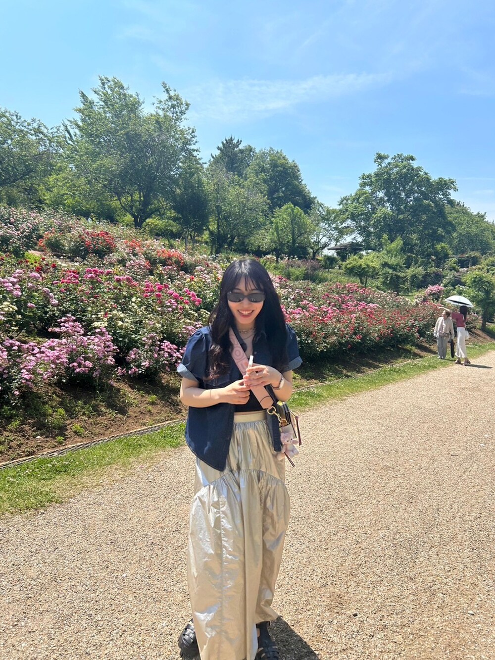 ホワイト系のスカート、ブルー系のセットアップ、ブラック系のサンダルを着用したレディースの夏コーディネートの2枚目の写真