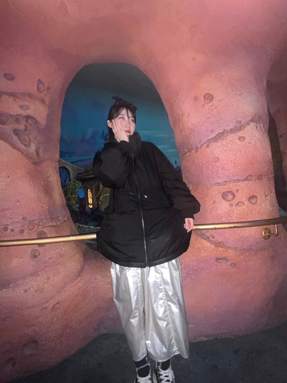 ブラック系のダウンジャケット/コート、ホワイト系のスカート、ブラック系のスニーカーを着用したレディースの春コーディネートの2枚目の写真