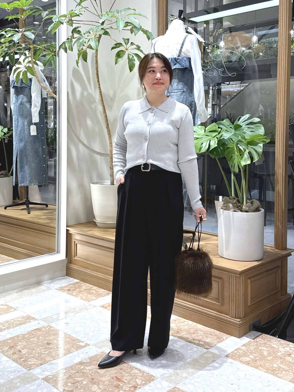 グレー系のニット/セーター、ブラック系のスラックス、ブラウン系のトートバッグを着用したレディースの秋コーディネートの3枚目の写真