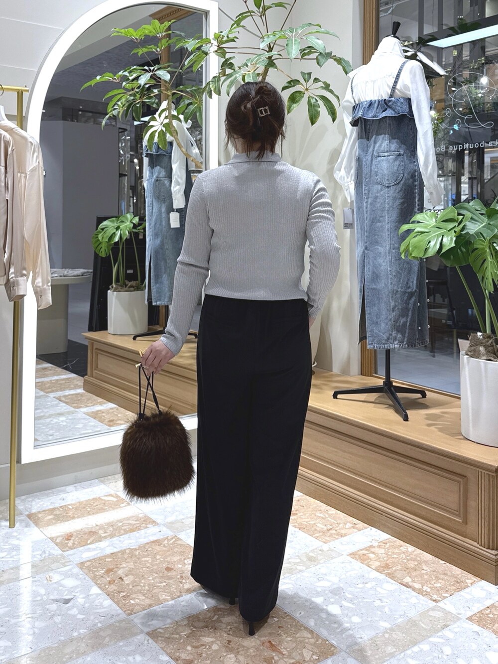 グレー系のニット/セーター、ブラック系のスラックス、ブラウン系のトートバッグを着用したレディースの秋コーディネートの4枚目の写真