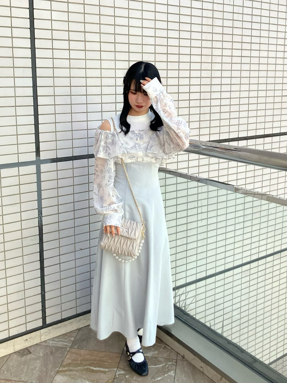 グレー系のワンピース、ベージュ系のショルダーバッグを着用したレディースの春コーディネートの2枚目の写真