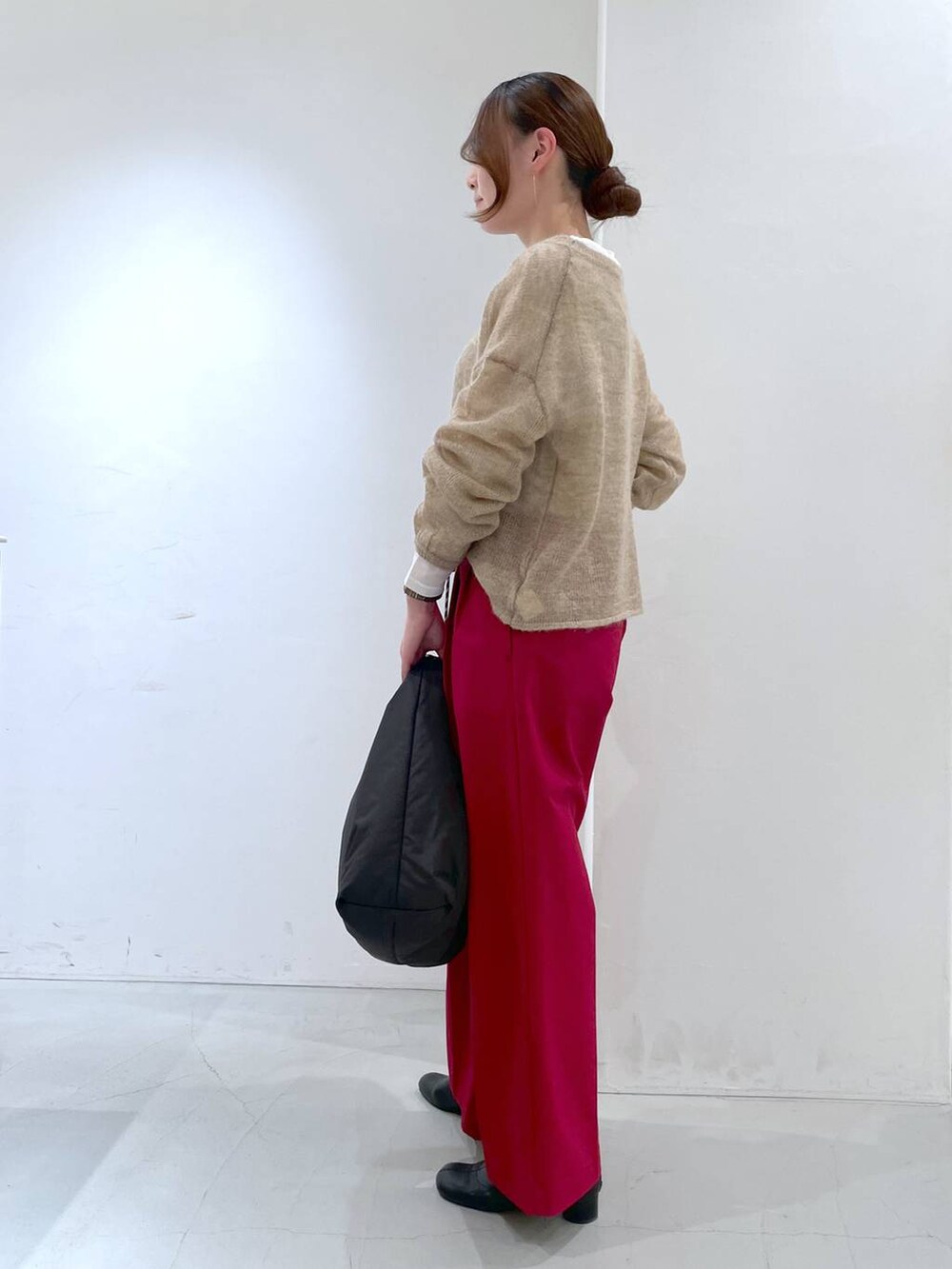 ホワイト系のTシャツ/カットソー、ベージュ系のニット/セーター、ブラック系のトートバッグを着用したレディースの冬コーディネートの2枚目の写真