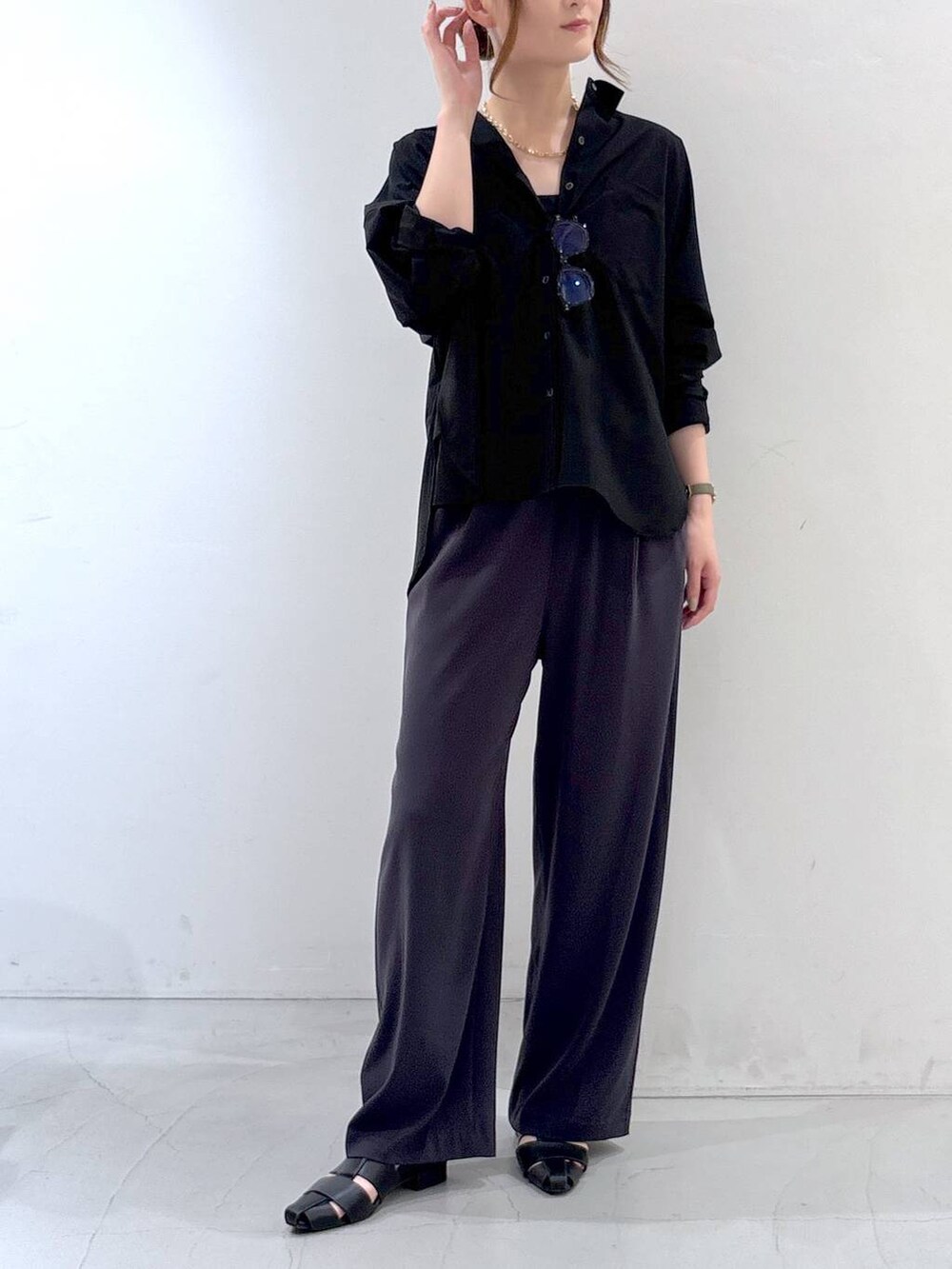 グレー系のスラックス、ブラック系のシャツ/ブラウス、ブラウン系のメガネを着用したレディースの夏コーディネートの2枚目の写真