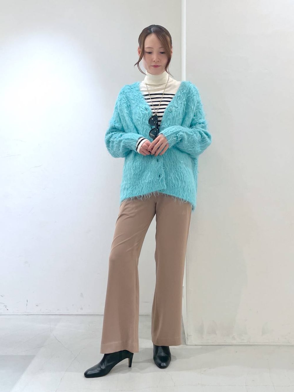 ブルー系のカーディガン/ボレロ、ホワイト系のニット/セーター、ベージュ系のその他パンツを着用したレディースの秋コーディネートの2枚目の写真