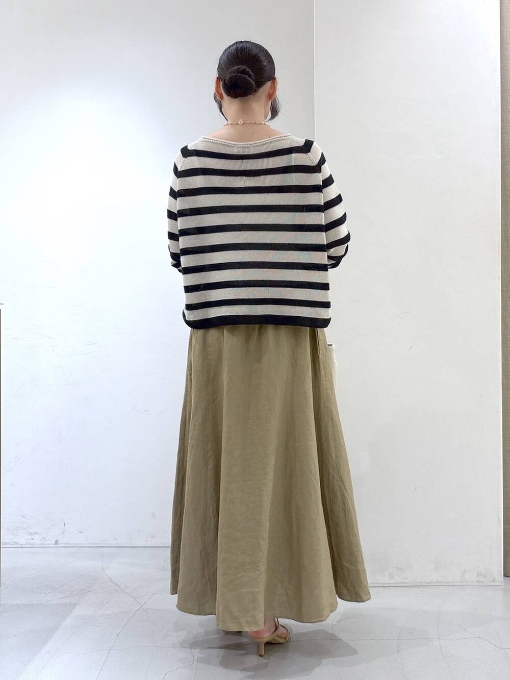 ベージュ系のニット/セーター、ベージュ系のスカート、ホワイト系のトートバッグを着用したレディースの春コーディネートの3枚目の写真