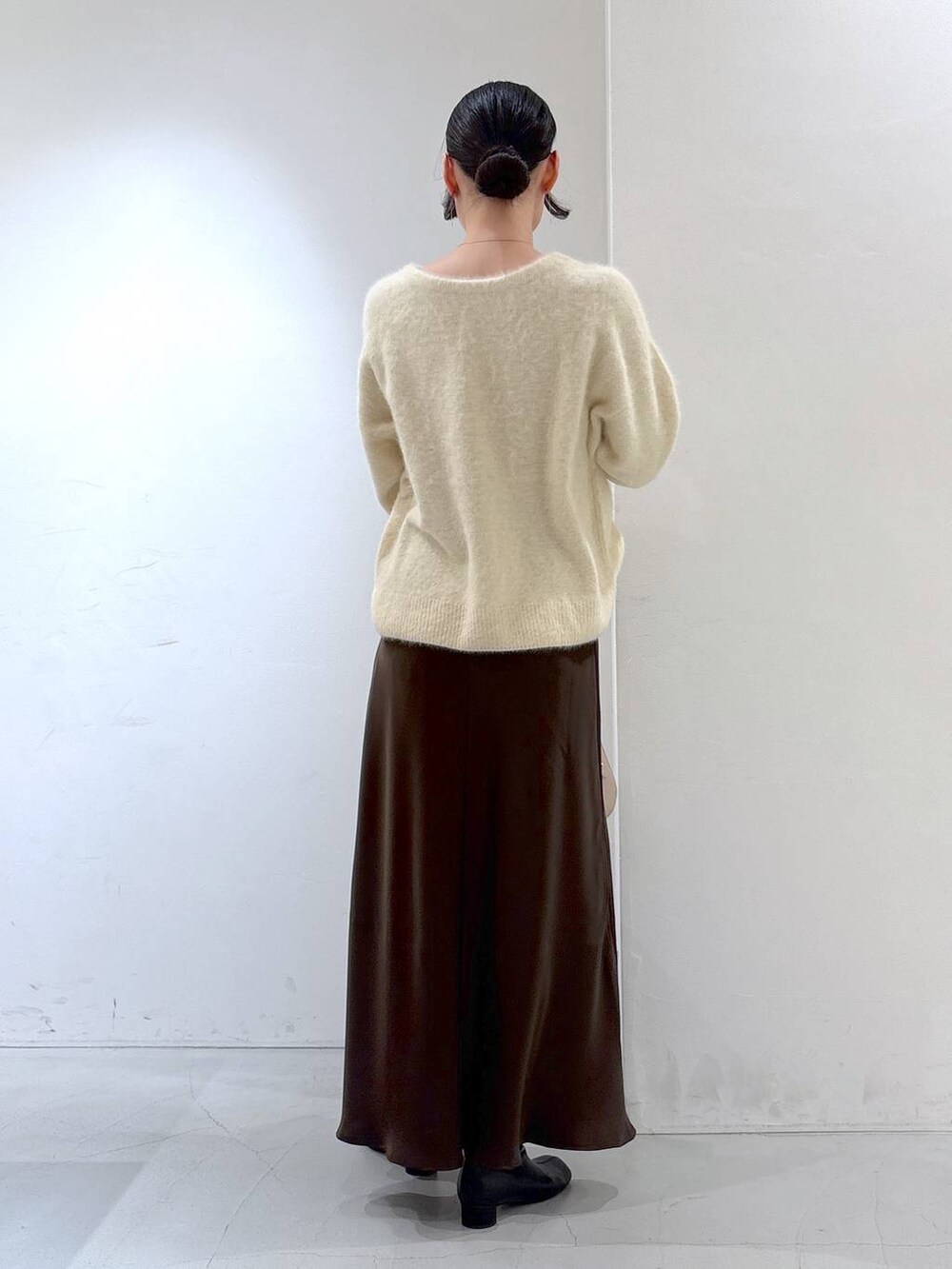 ベージュ系のニット/セーター、ベージュ系のボストンバッグ、ブラウン系のスカートを着用したレディースの冬コーディネートの4枚目の写真