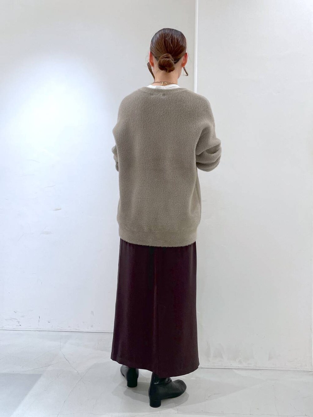 ホワイト系のTシャツ/カットソー、ブラウン系のカーディガン/ボレロ、ブラウン系のスカートを着用したレディースの冬コーディネートの5枚目の写真