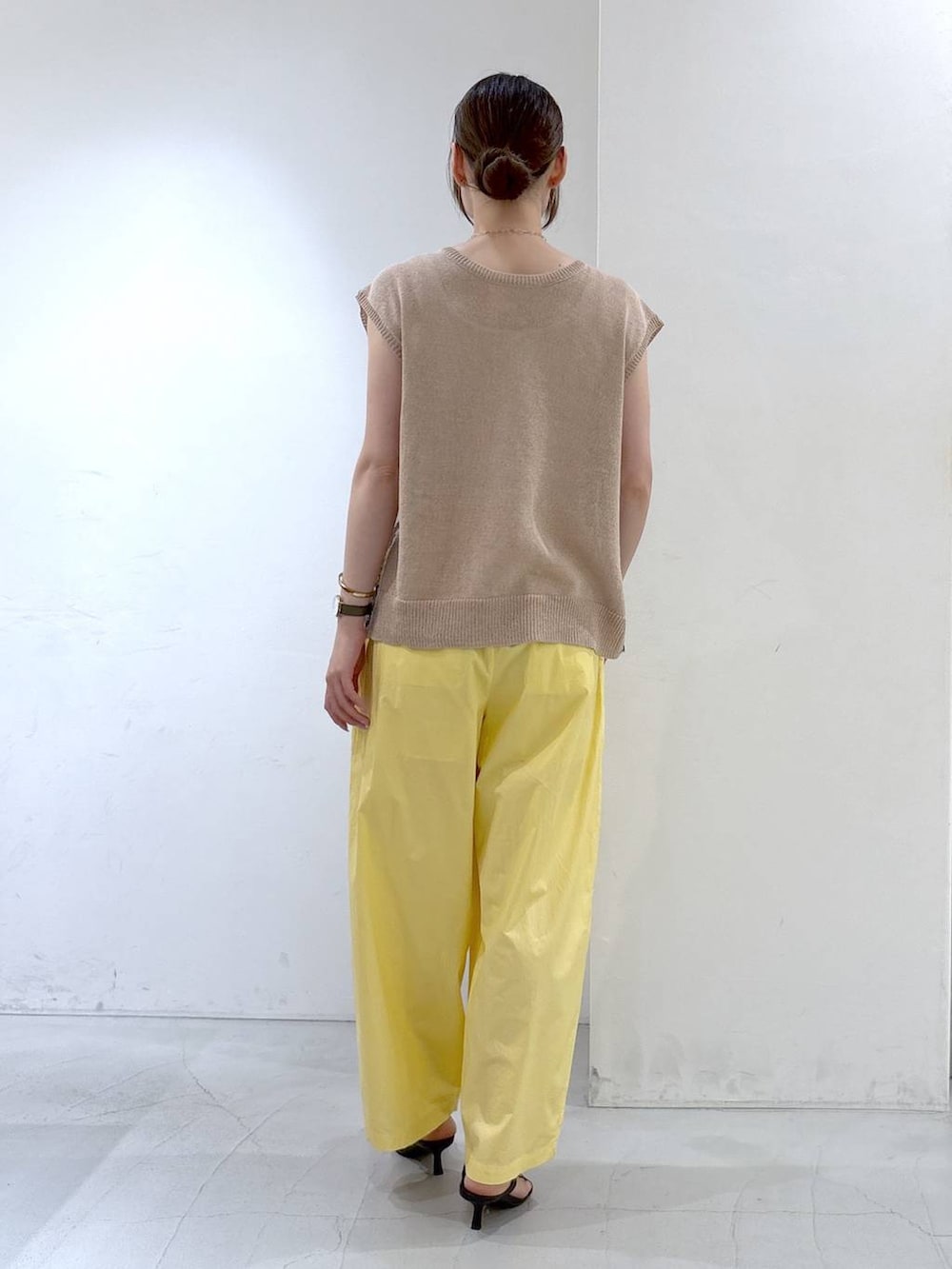 イエロー系のその他パンツ、ベージュ系のニット/セーターを着用したレディースの夏コーディネートの4枚目の写真