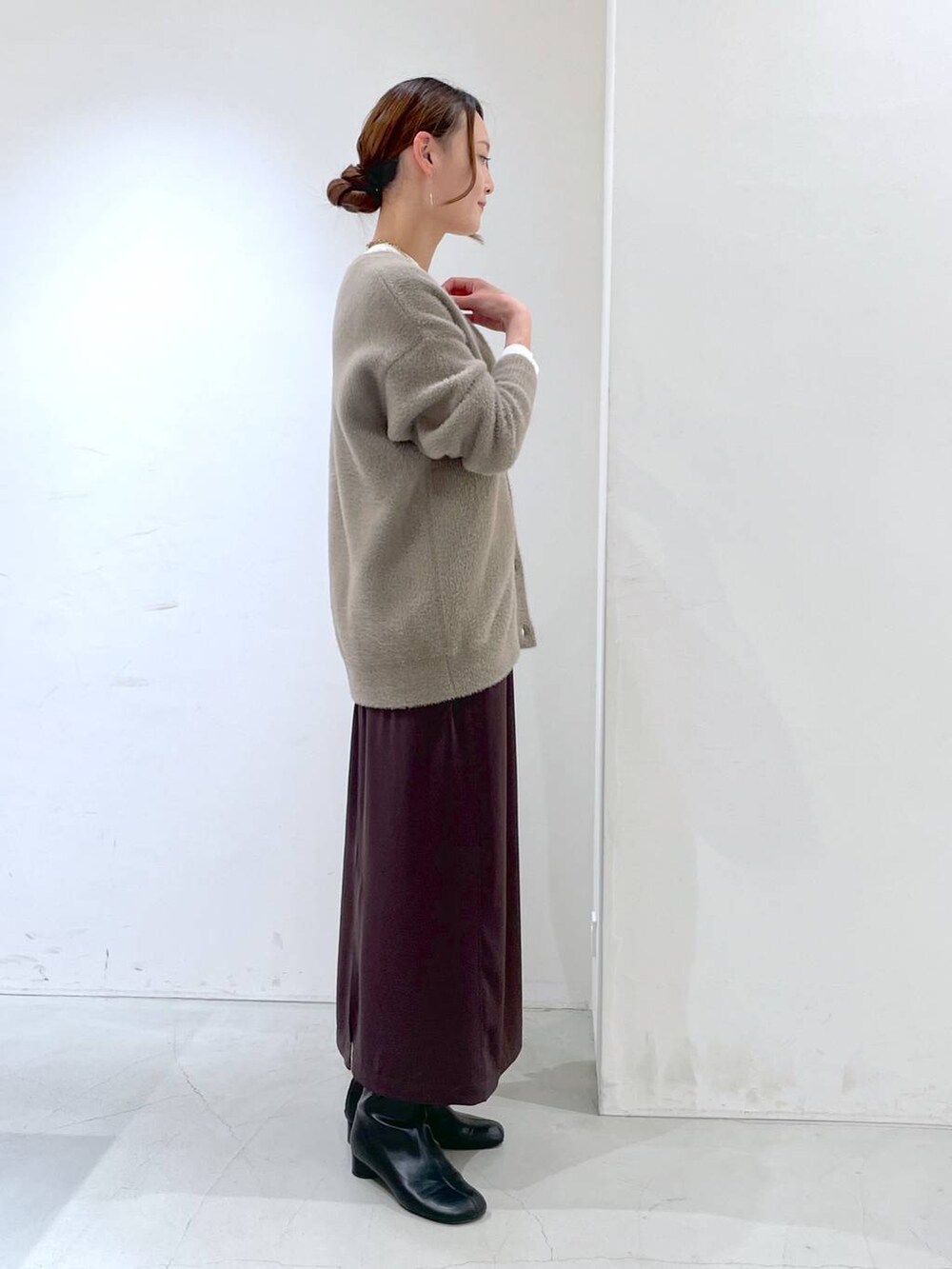 ホワイト系のTシャツ/カットソー、ブラウン系のカーディガン/ボレロ、ブラウン系のスカートを着用したレディースの冬コーディネートの4枚目の写真