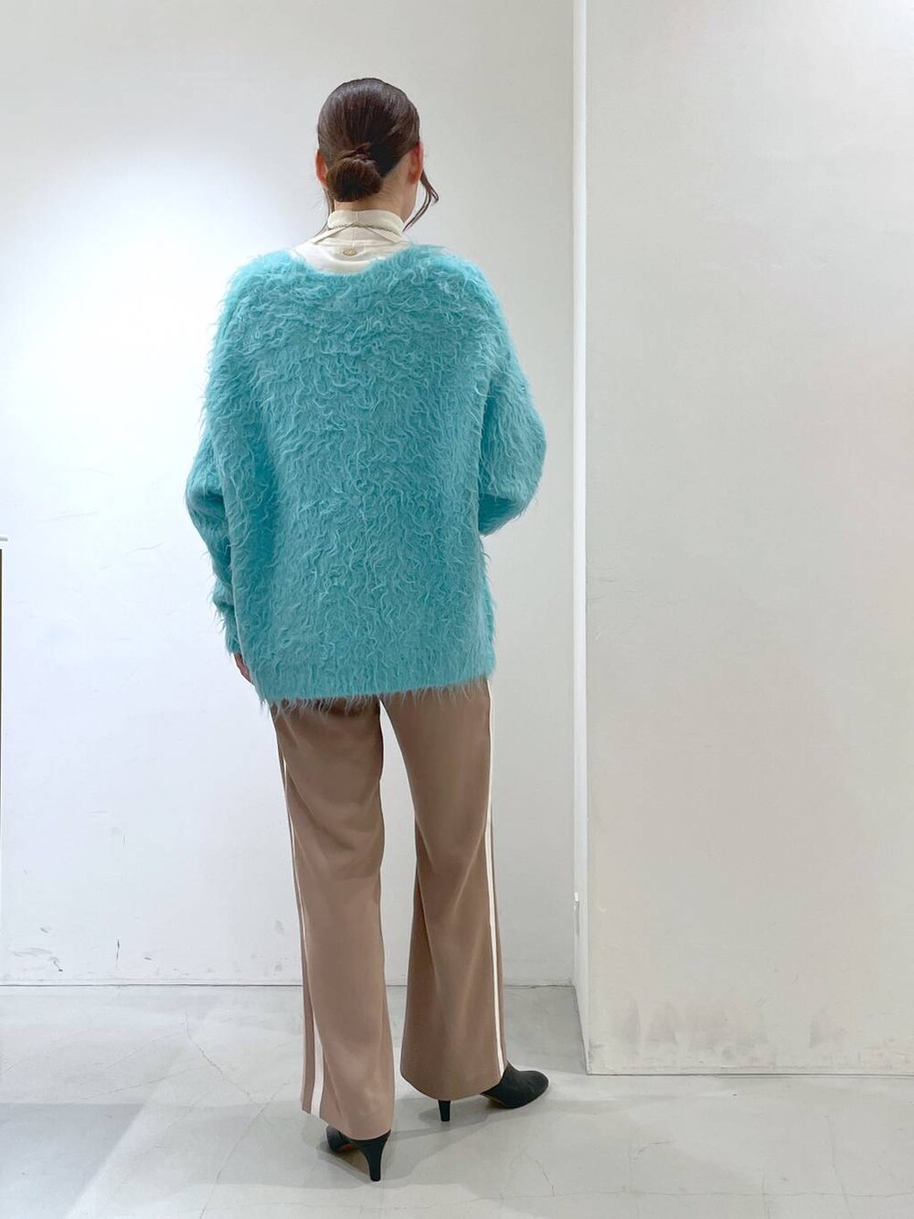 ブルー系のカーディガン/ボレロ、ホワイト系のニット/セーター、ベージュ系のその他パンツを着用したレディースの秋コーディネートの5枚目の写真