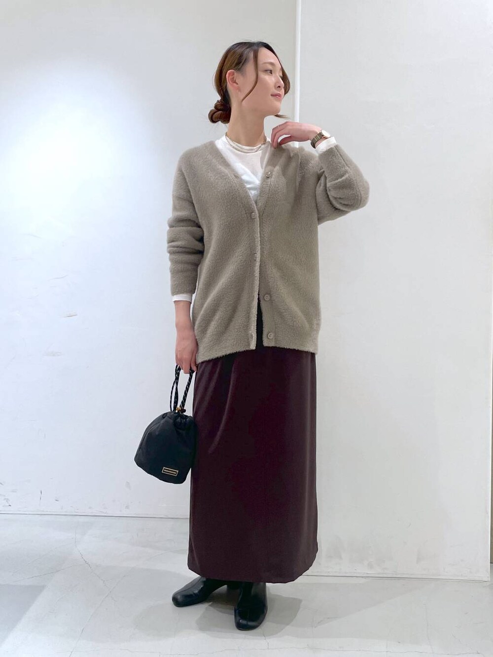 ホワイト系のTシャツ/カットソー、ブラウン系のカーディガン/ボレロ、ブラウン系のスカートを着用したレディースの冬コーディネートの2枚目の写真