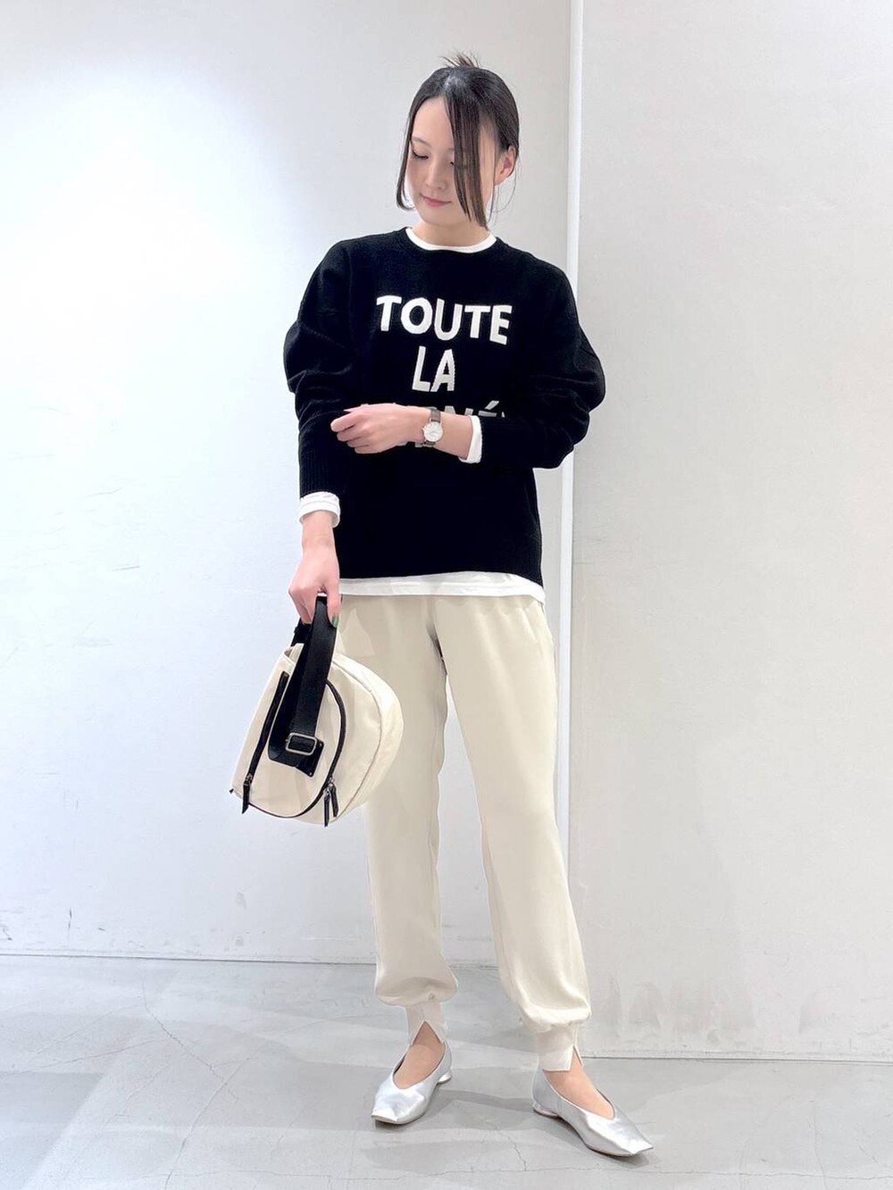 ホワイト系のTシャツ/カットソー、ブラック系のニット/セーター、ホワイト系のその他パンツを着用したレディースの冬コーディネートの2枚目の写真