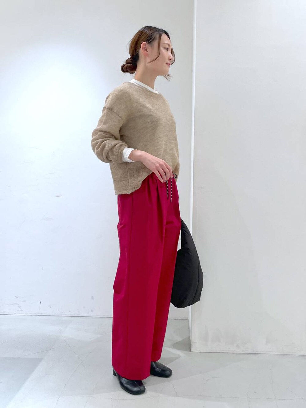 ホワイト系のTシャツ/カットソー、ベージュ系のニット/セーター、ブラック系のトートバッグを着用したレディースの冬コーディネートの3枚目の写真