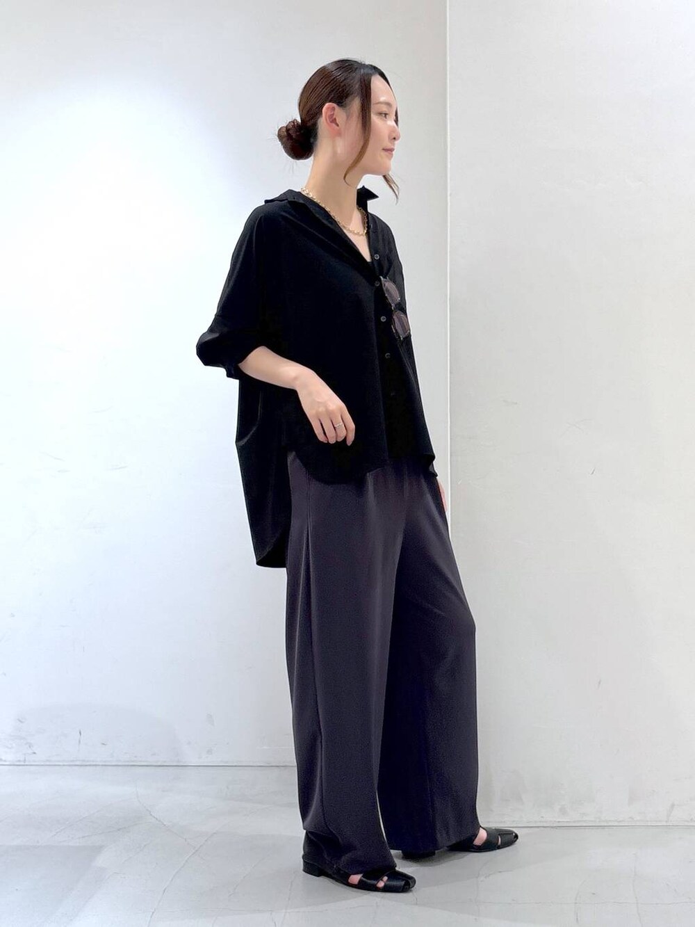 グレー系のスラックス、ブラック系のシャツ/ブラウス、ブラウン系のメガネを着用したレディースの夏コーディネートの3枚目の写真