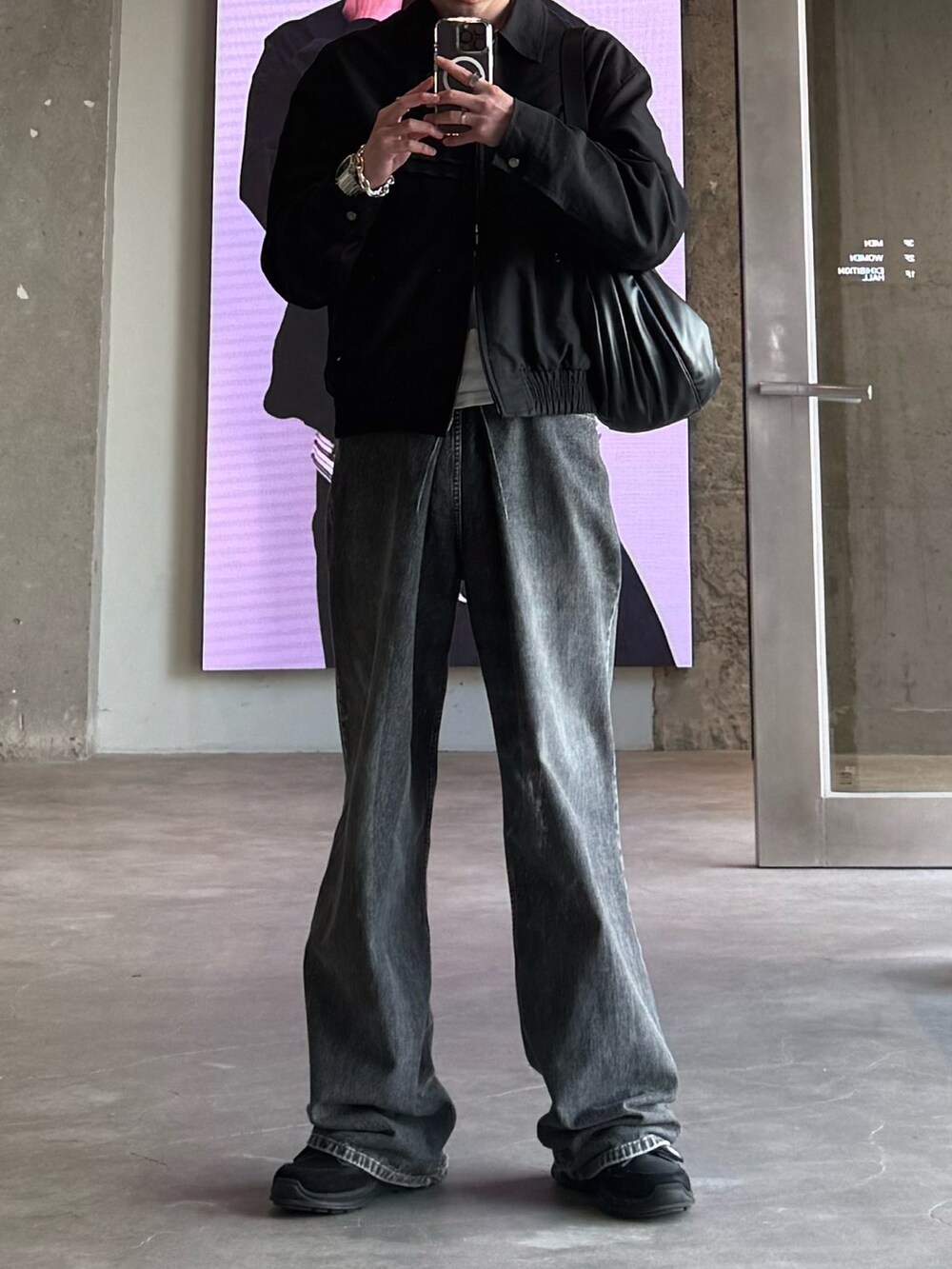 グレー系のデニムパンツ、ブラック系のショルダーバッグ、ホワイト系のTシャツ/カットソーを着用したメンズの春コーディネートの2枚目の写真