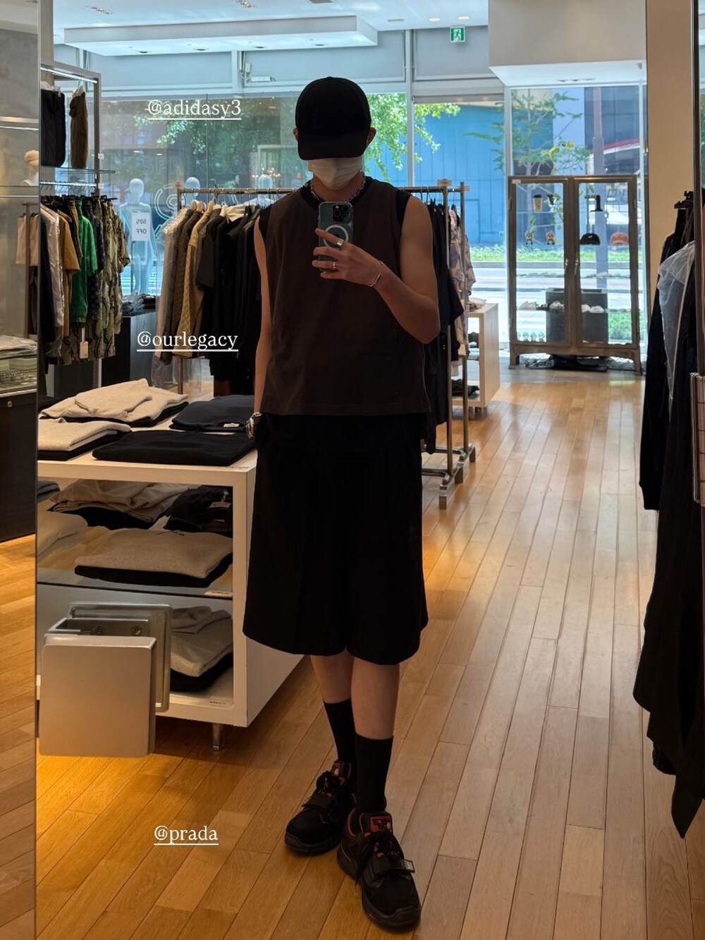 ブラウン系のタンクトップ、ブラック系のスニーカー、ブラック系のキャップを着用したメンズの夏コーディネートの2枚目の写真