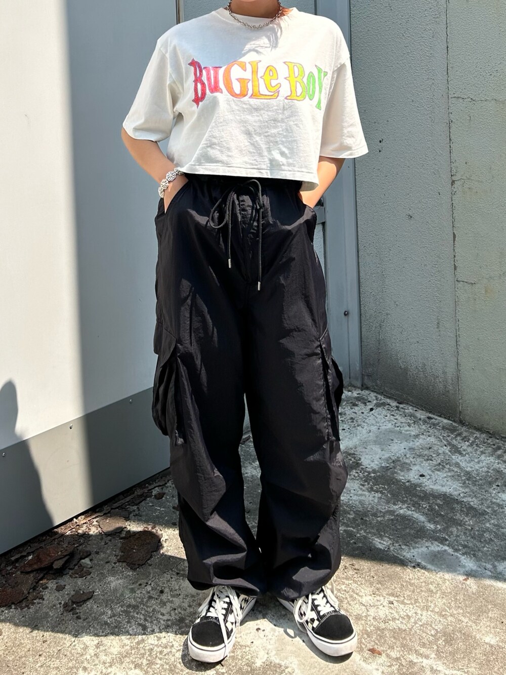 ブラック系のカーゴパンツ、ホワイト系のTシャツ/カットソーを着用したレディースの夏コーディネートの2枚目の写真