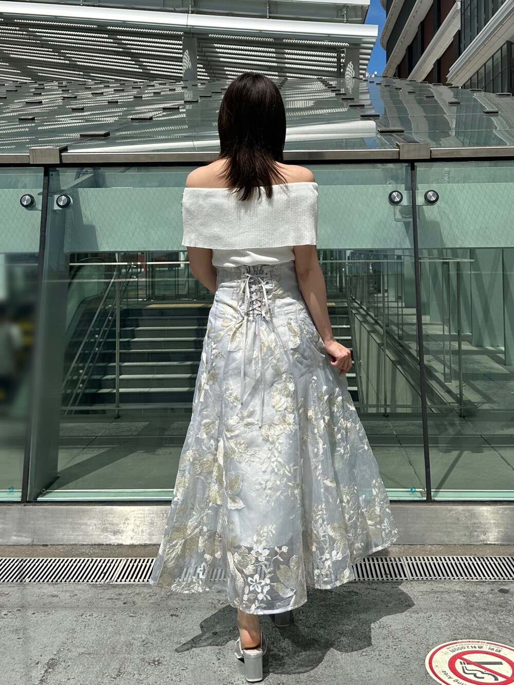 グレー系のスカート、グレー系のニット/セーター、シルバー系のパンプスを着用したレディースの夏コーディネートの4枚目の写真