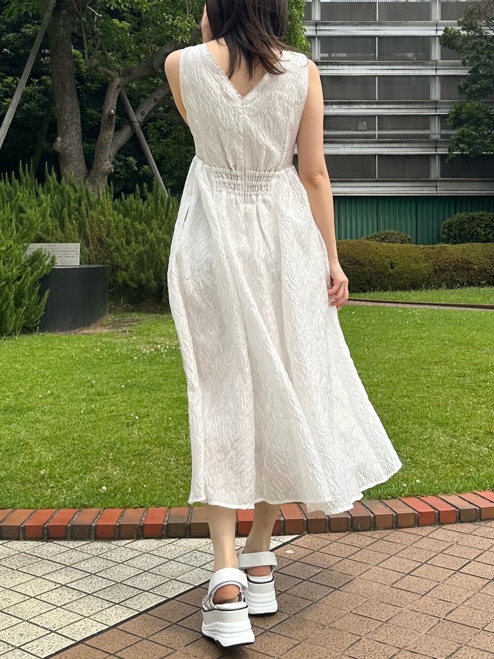 ホワイト系のドレス、ホワイト系のサンダルを着用したレディースの夏コーディネートの3枚目の写真