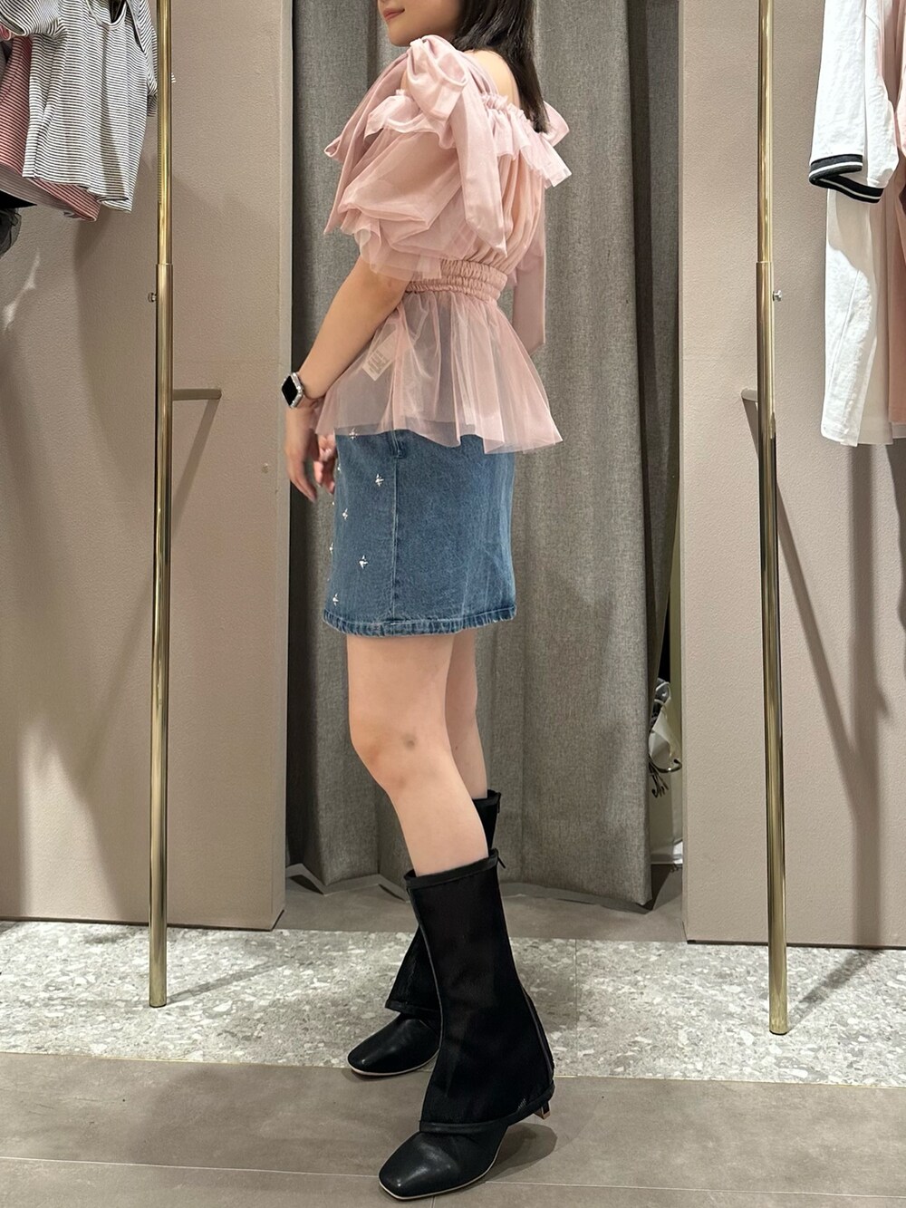 ピンク系のシャツ/ブラウス、ブルー系のデニムスカート、ブラック系のブーツを着用したレディースの春コーディネートの2枚目の写真