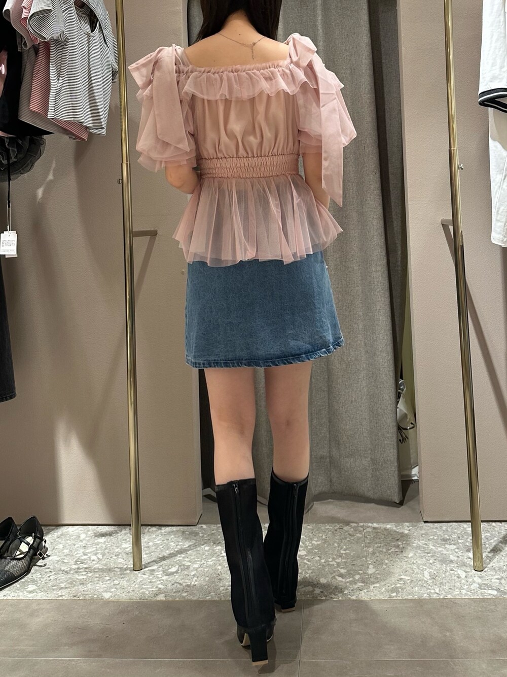 ピンク系のシャツ/ブラウス、ブルー系のデニムスカート、ブラック系のブーツを着用したレディースの春コーディネートの4枚目の写真