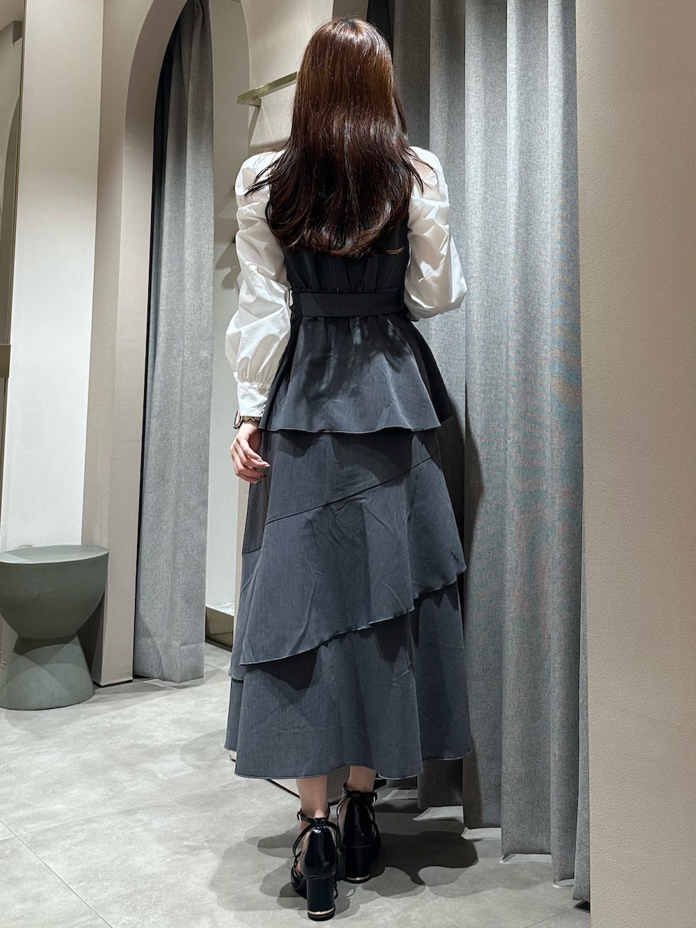 グレー系のワンピース、グレー系のワンピース、ブラック系のサンダルを着用したレディースの冬コーディネートの7枚目の写真