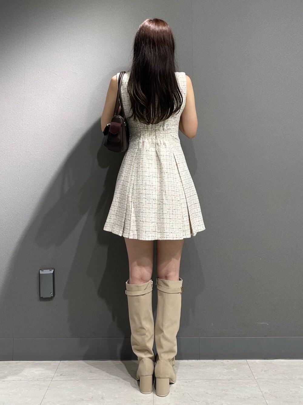 ホワイト系のワンピース、ブラウン系のボストンバッグ、ホワイト系のブーツを着用したレディースの夏コーディネートの7枚目の写真