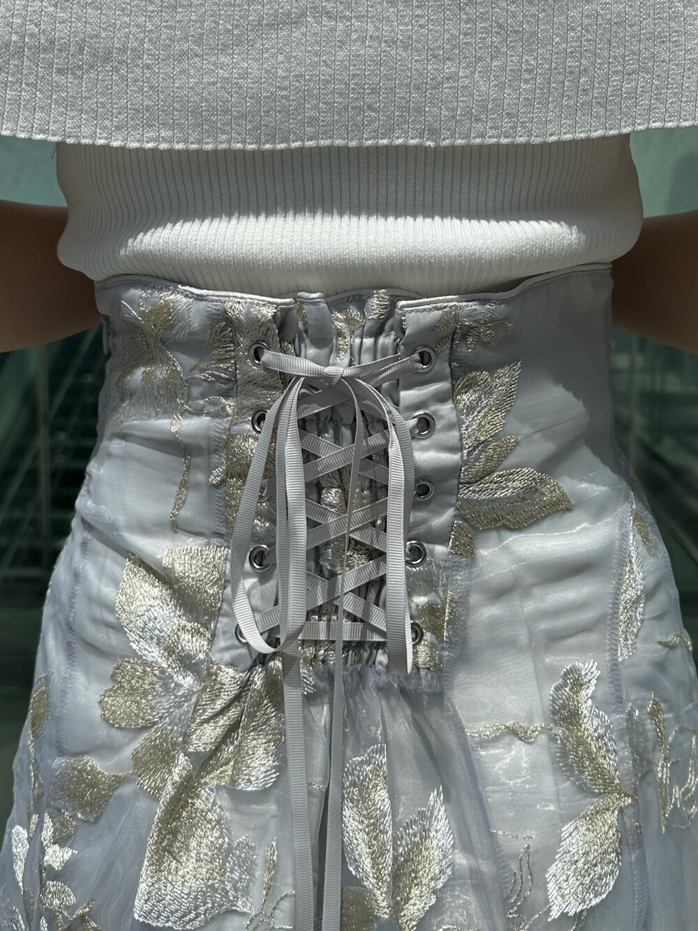 グレー系のスカート、グレー系のニット/セーター、シルバー系のパンプスを着用したレディースの夏コーディネートの6枚目の写真