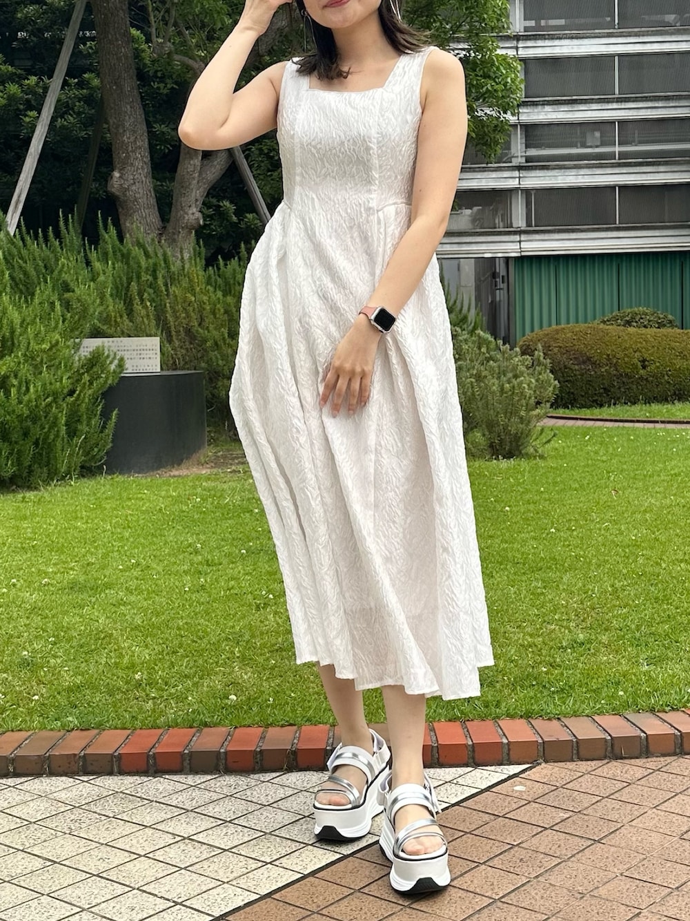 ホワイト系のドレス、ホワイト系のサンダルを着用したレディースの夏コーディネートの2枚目の写真