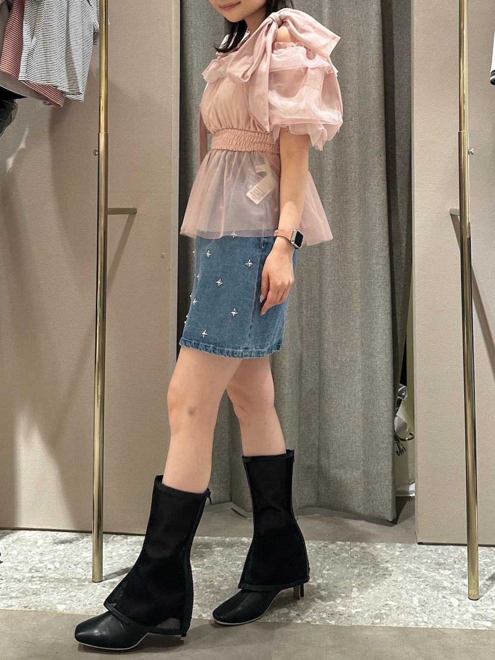 ピンク系のシャツ/ブラウス、ブルー系のデニムスカート、ブラック系のブーツを着用したレディースの春コーディネートの3枚目の写真