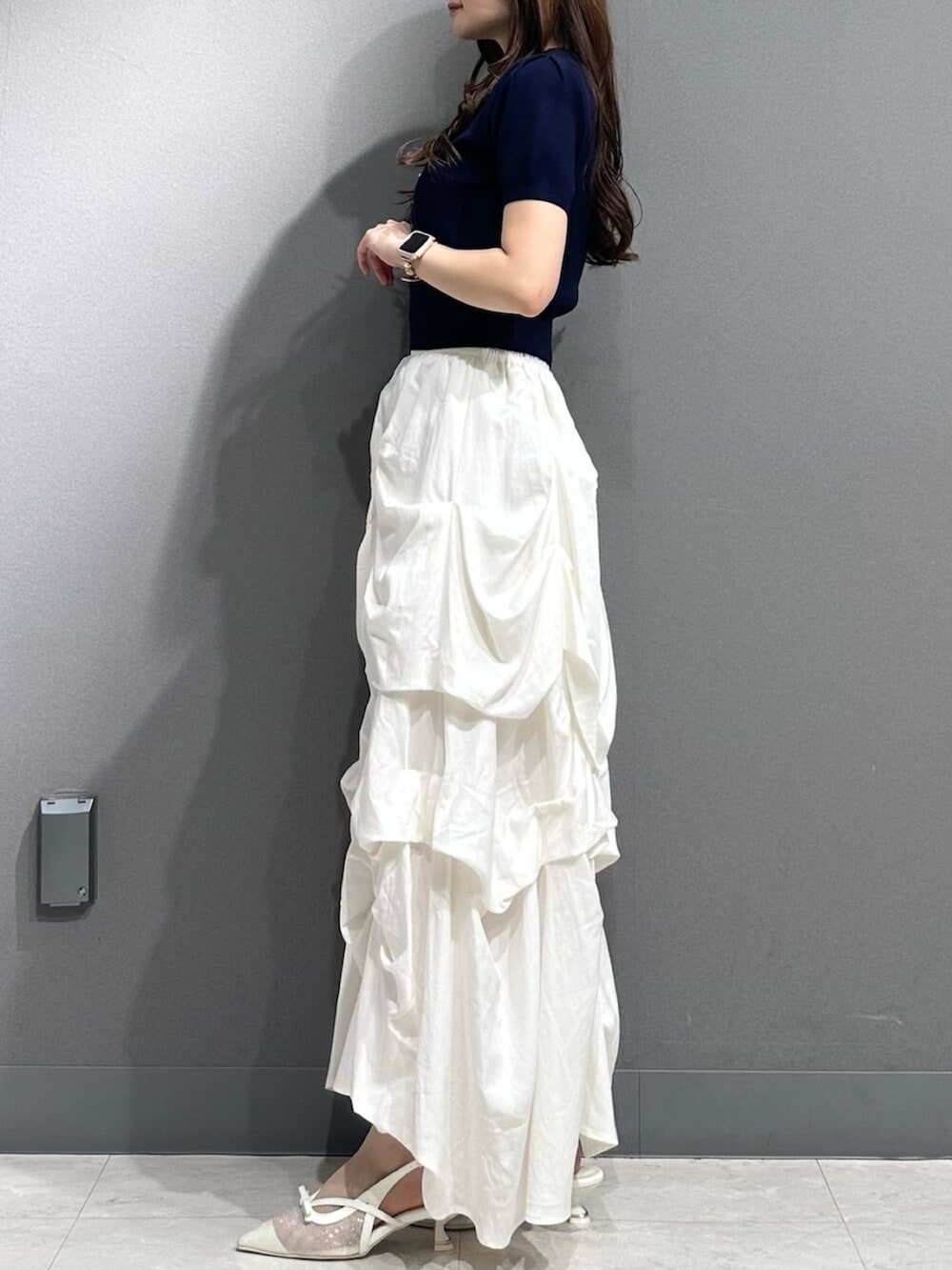 ホワイト系のパンプス、ブルー系のニット/セーター、ホワイト系のスカートを着用したレディースの春コーディネートの6枚目の写真