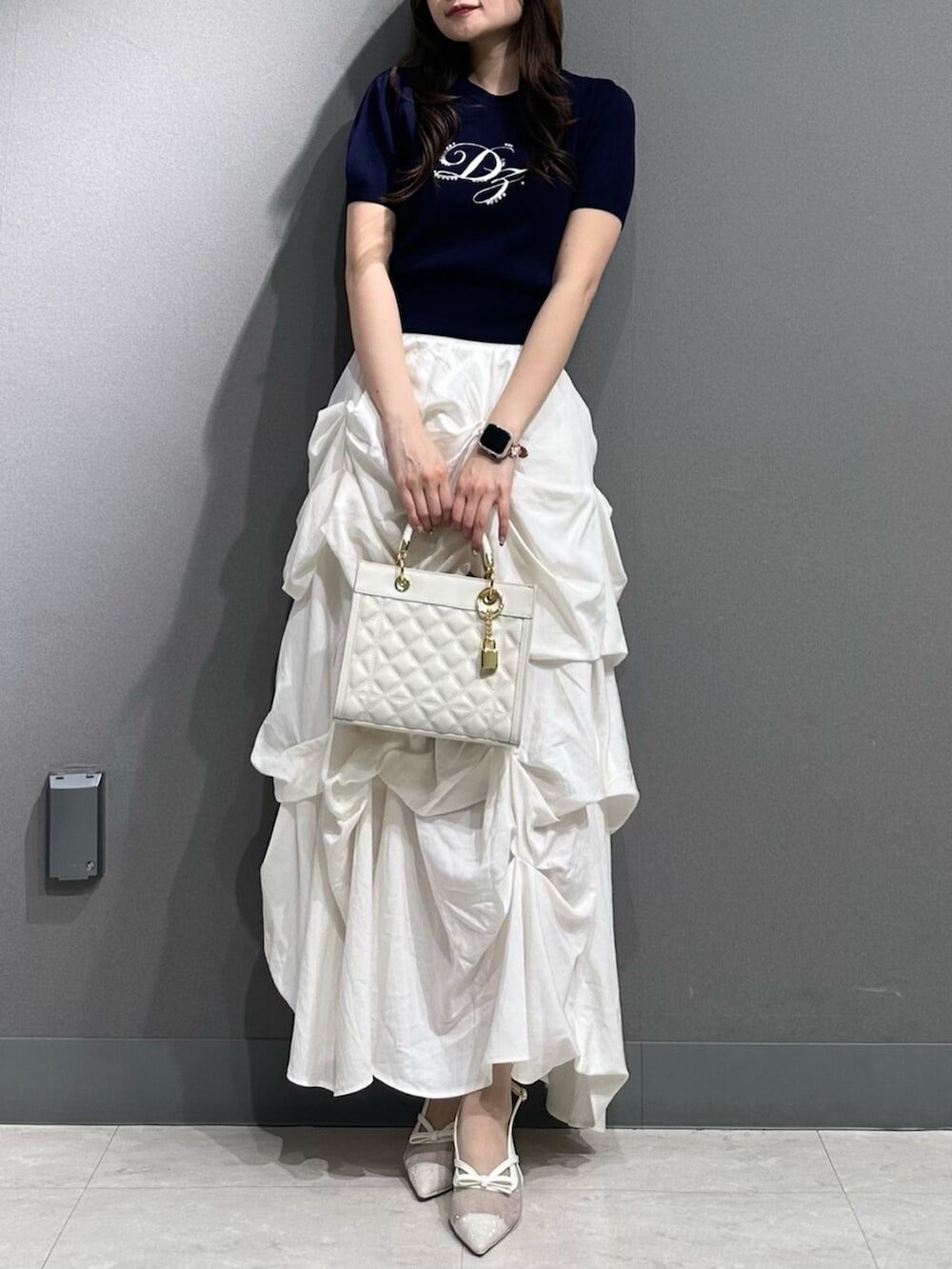 ホワイト系のパンプス、ブルー系のニット/セーター、ホワイト系のスカートを着用したレディースの春コーディネートの4枚目の写真