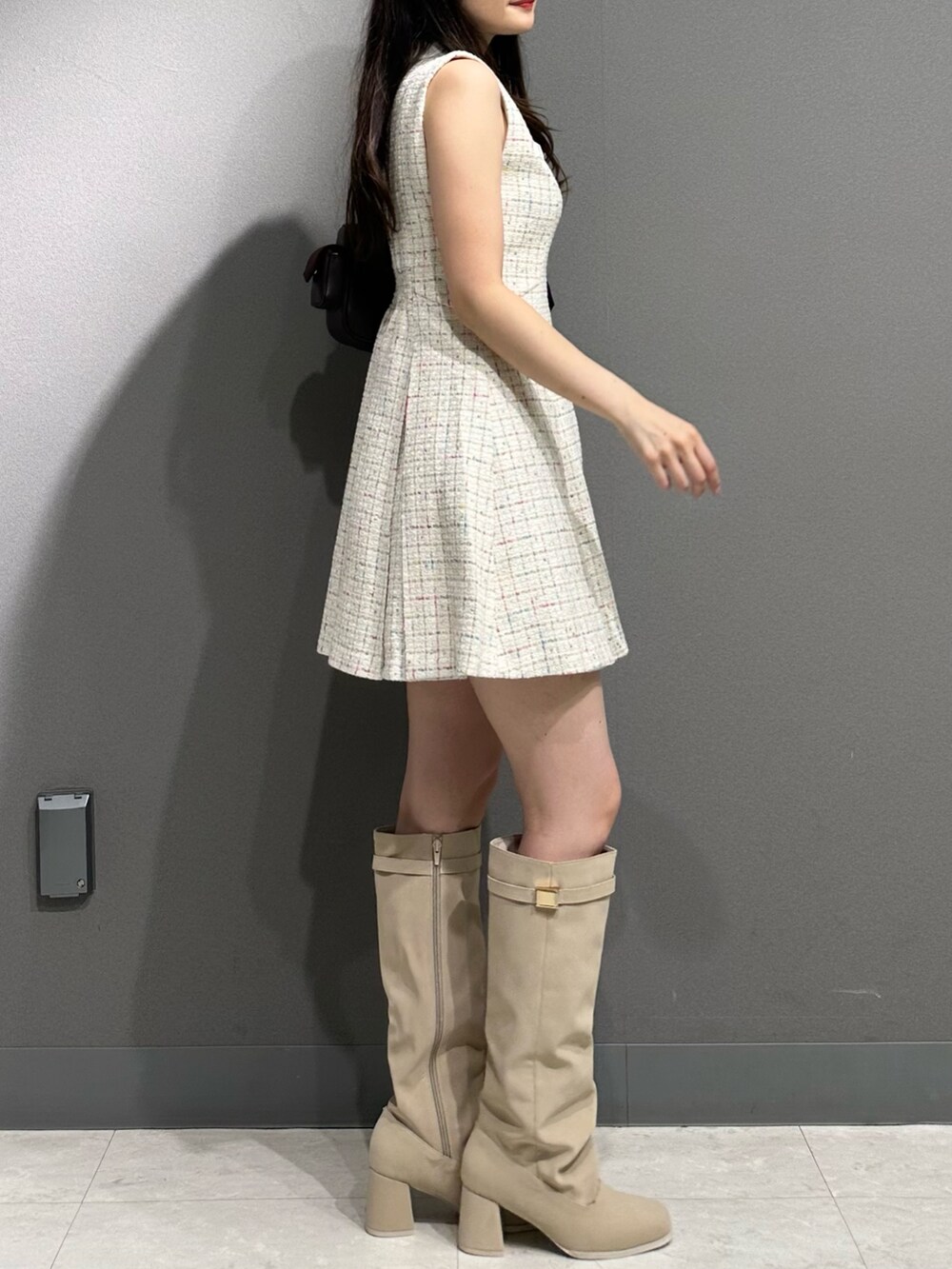 ホワイト系のワンピース、ブラウン系のボストンバッグ、ホワイト系のブーツを着用したレディースの夏コーディネートの6枚目の写真